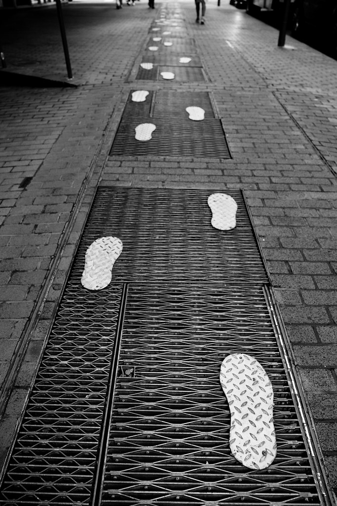 Johny Vino black and white abstract photograph of crosswalk footprints