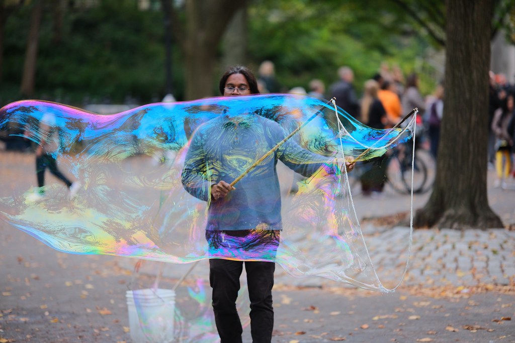 Johny Vino action photograph of a giant soap bubble in the park